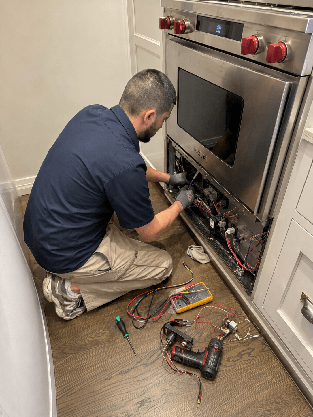 Technician repairing a Wolf appliance